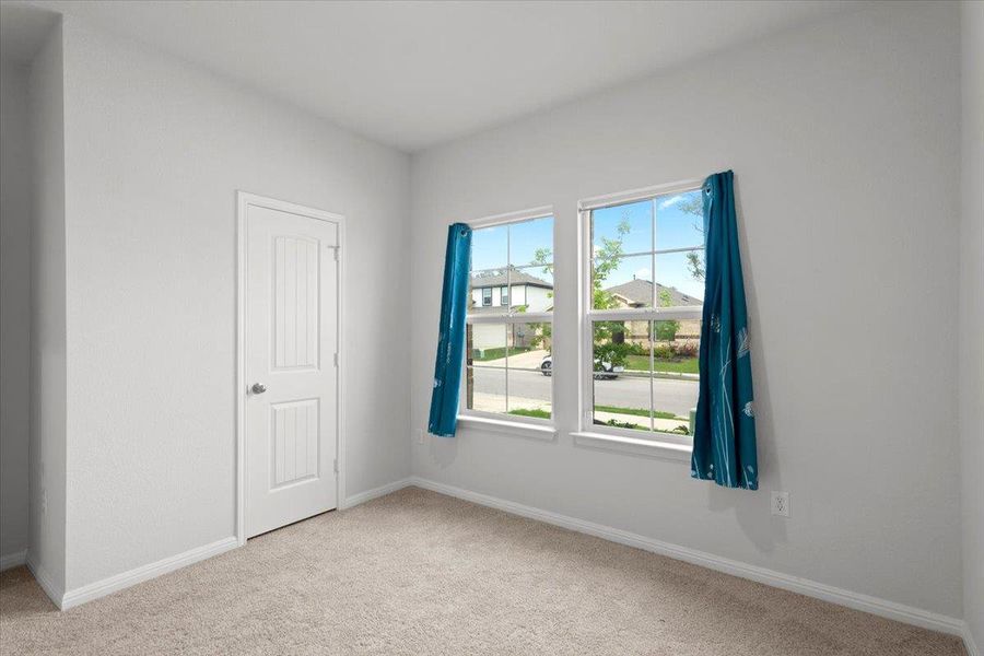 Neutral-toned room featuring a light beige carpet, white baseboards, and painted walls