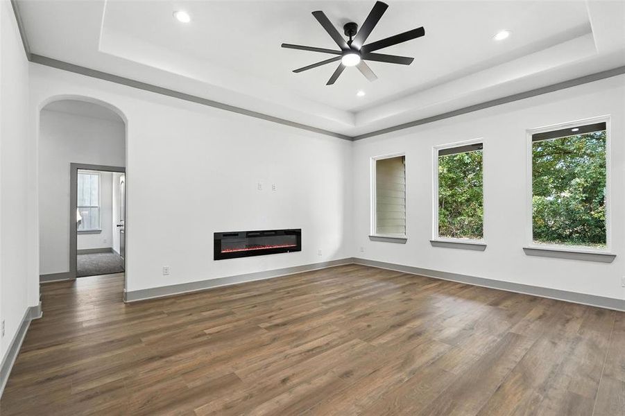 Unfurnished living room with a raised ceiling, plenty of natural light, and recessed lighting Unfurnished living room with a raised ceiling, plenty of natural light, and recessed lighting