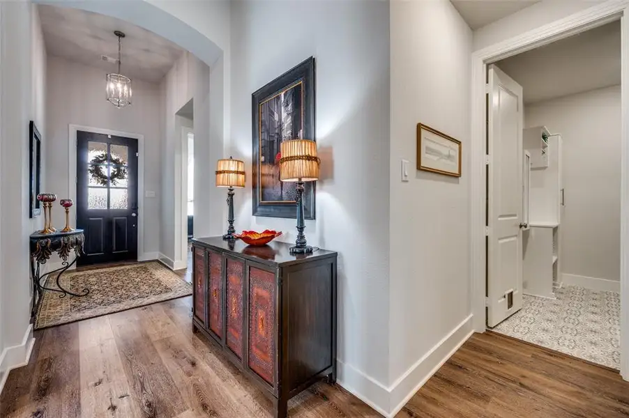Entryway featuring wood finished floors, arched walkways, and hanging lights