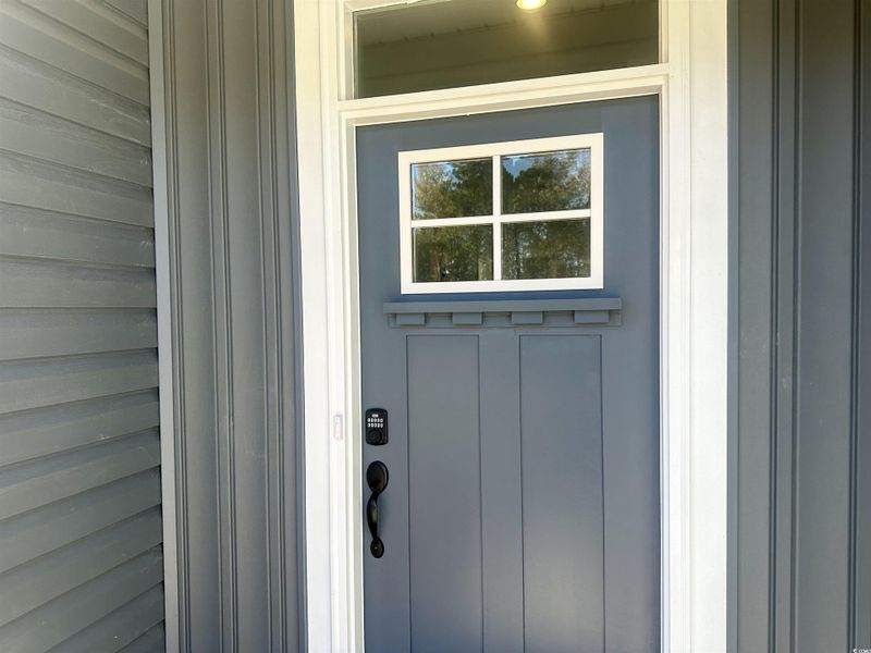 Entrance to property with board and batten siding and keyless entry. Entrance to property with board and batten siding and keyless entry.