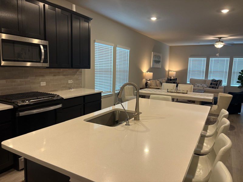 An open concept design seamlessly connects the culinary space with a comfortable living area.