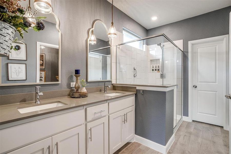 Full bathroom featuring wood finished floors, a sink, and a shower stall