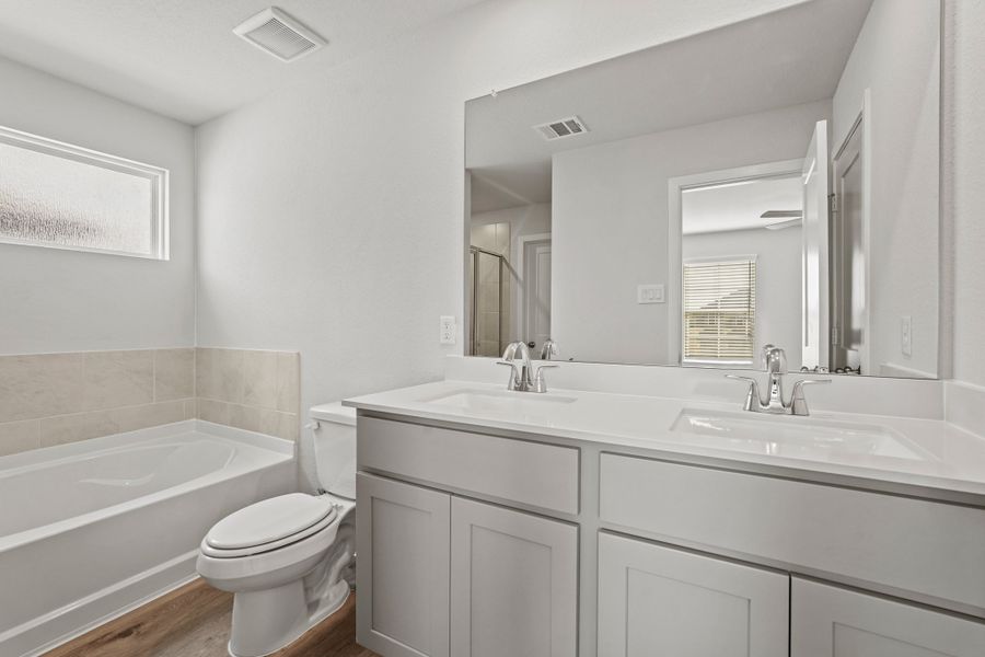 A bathroom with a tub sink and toilet.