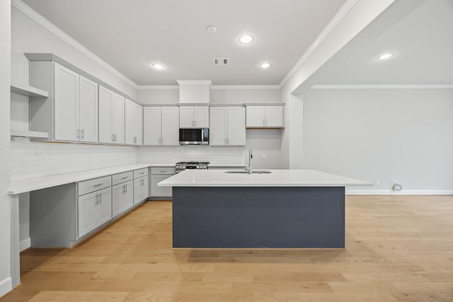 Designer Finishes Meet Everyday Function: Timeless meets trendy in this gourmet kitchen with Benedettini cabinets with soft-close drawers, quartz countertops, and custom design selections. The open layout keeps you connected to the living and dining spaces beyond.