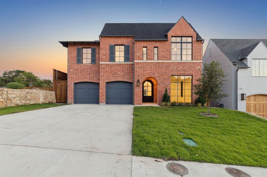 View of front of home featuring a yard and a garage