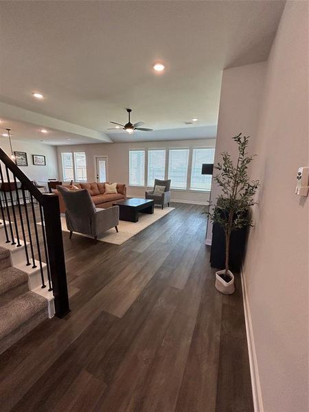 Living room with dark wood-style floors, stairway, recessed lighting, and a ceiling fan Living room with dark wood-style floors, stairway, recessed lighting, and a ceiling fan