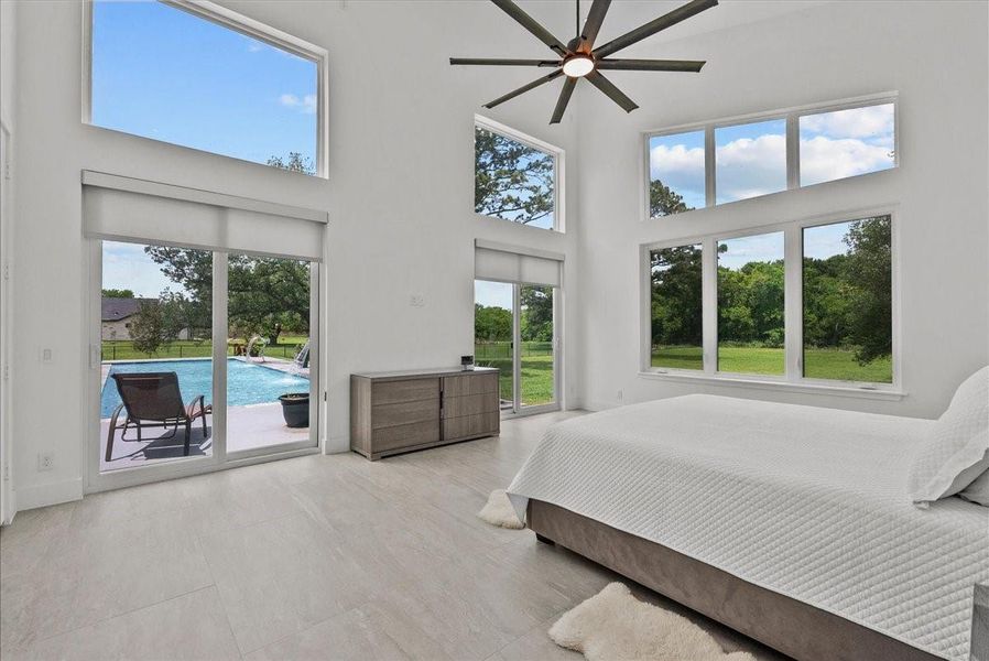 25ft ceilings, clerestory windows, and a modern designer fan highlight the expansive primary suite.