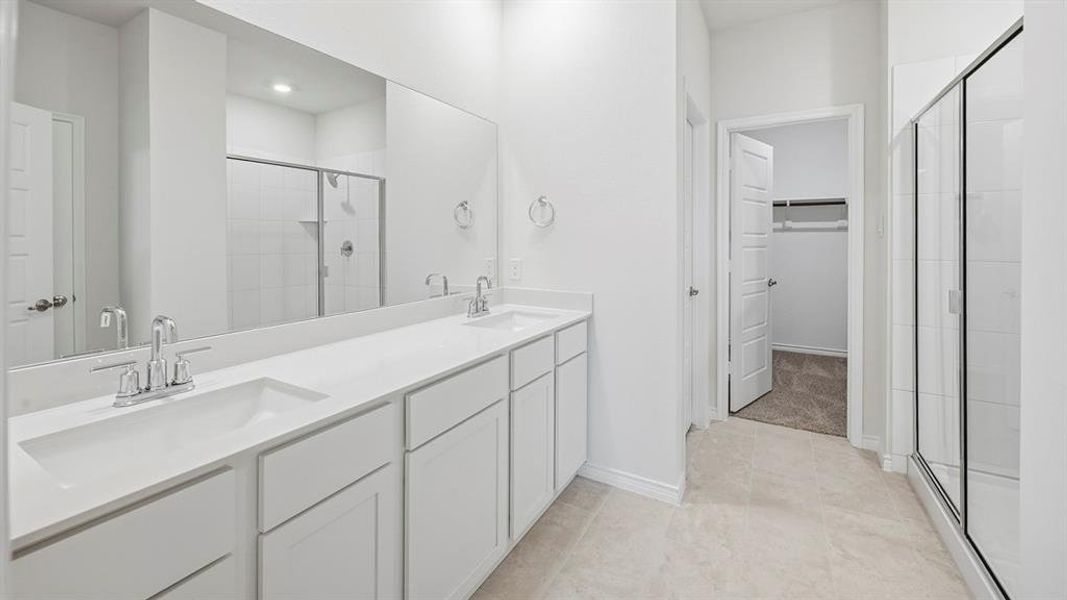 Bright bathroom featuring a double vanity with integrated sinks, chrome fixtures, and a large mirror