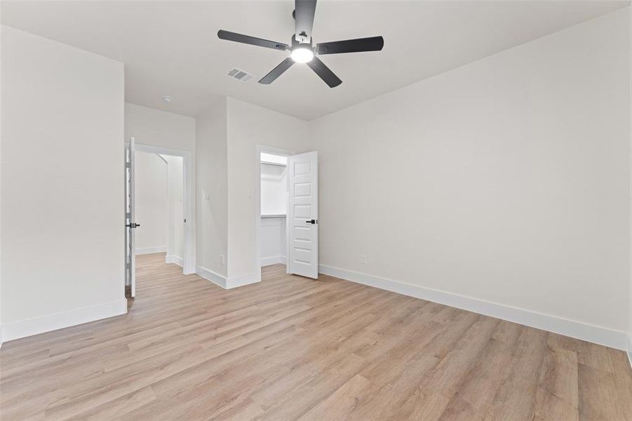 Unfurnished bedroom with light wood-type flooring, baseboards, a closet, and a ceiling fan Unfurnished bedroom with light wood-type flooring, baseboards, a closet, and a ceiling fan