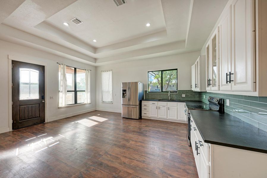 Rich wood flooring pairs elegantly with recessed lighting and custom cabinetry in this modern space.