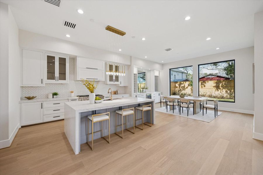 The heart of the home lies in the chef's dream kitchen boasting Thermador appliances, including a professional-grade gas range, all centered around a massive island that invites culinary creativity and socializing.