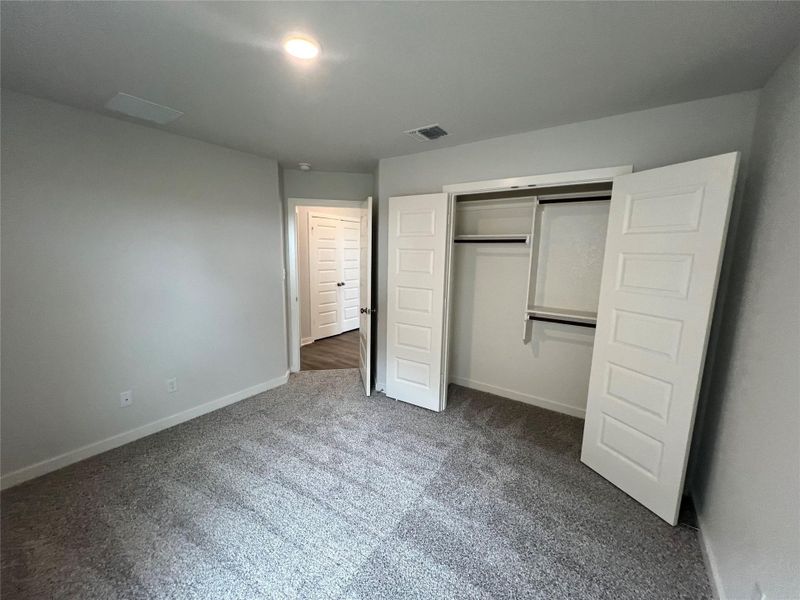 A well-proportioned bedroom offers comfort with a spacious closet and plush carpeting.