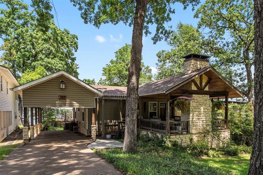 Stone and siding exterior with a covered front porch featuring a dark wood railing