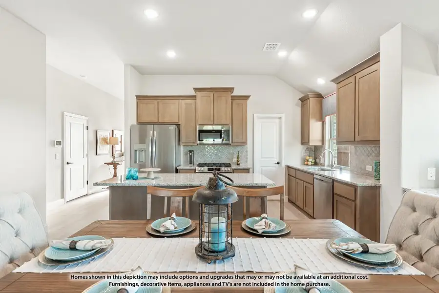 Open kitchen with brown cabinets, granite island, stainless appliances, and dining table in foreground Open kitchen with brown cabinets, granite island, stainless appliances, and dining table in foreground