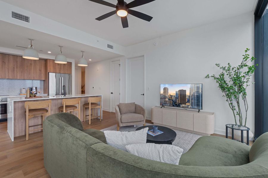 Representative Photo. Open Concept living room with 7.5" wide Bella Cera hardwood flooring, recessed lighting, ceiling fan, and a balcony off the living room with a North West view