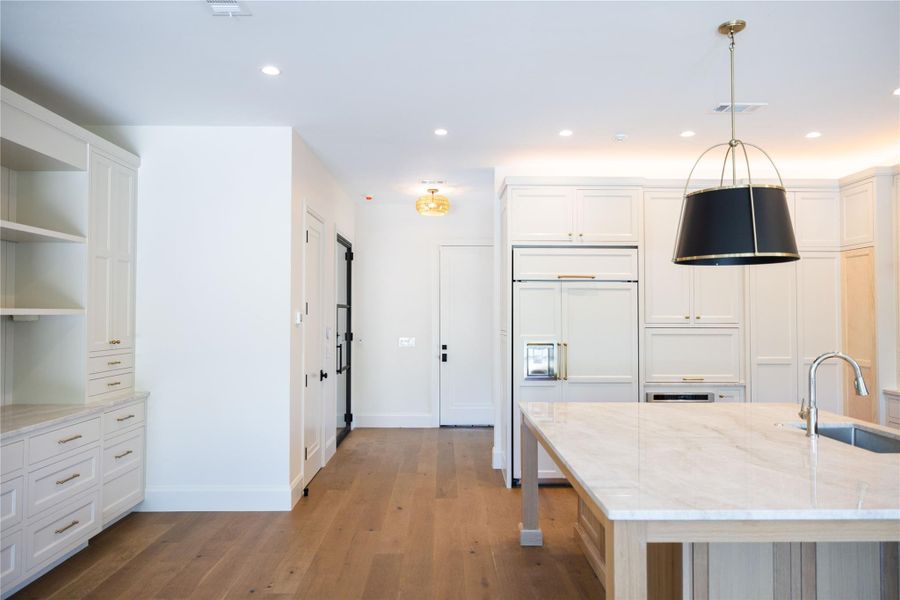 Kitchen featuring a sink, paneled refrigerator, light wood-type flooring, open shelves, and recessed lighting