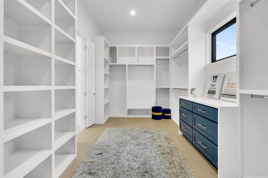 Walk in closet with light wood-style floors