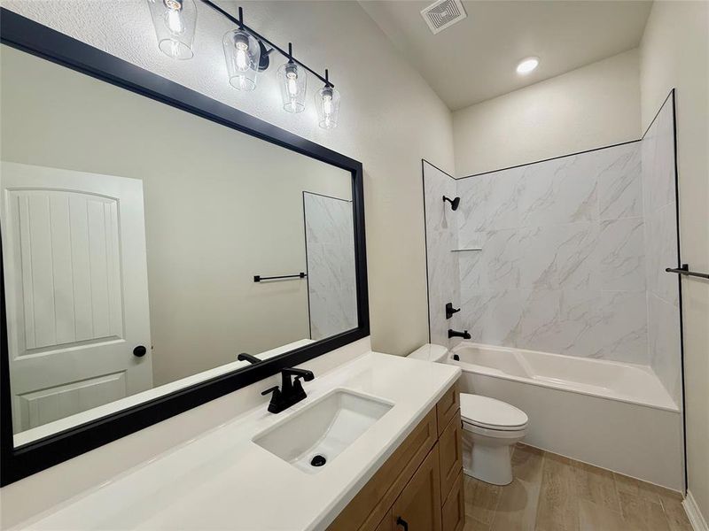 Bathroom featuring vanity, shower / bathtub combination, and wood finished floors
