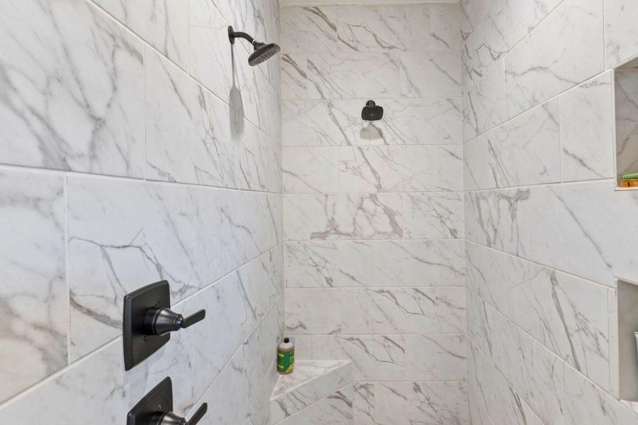 Full bathroom with a marble finish shower