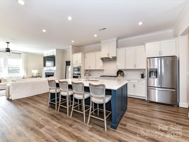 Kitchen offers quartz counters, stainless steel appliances, gas cook top, huge 8' island, custom lighting, plenty of cabinets for storage & pantry!