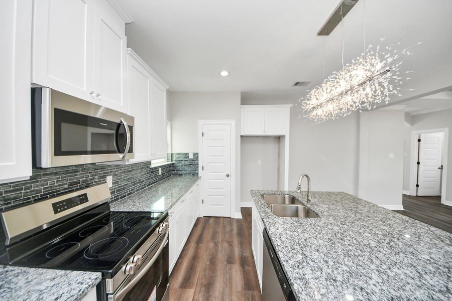 This beautifully designed kitchen offers an abundance of counter and cabinet space, providing plenty of storage to keep everything organized and within reach. The stylish flooring complements the cabinetry perfectly, creating a seamless and inviting look, while the spacious walk-in pantry ensures you’ll never run out of room for all your kitchen essentials  - (representation photo).