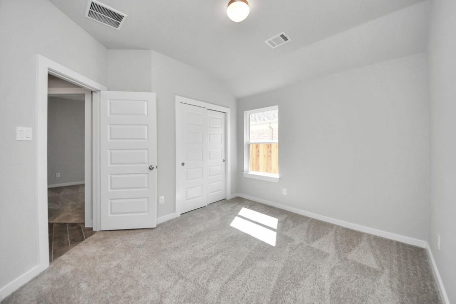 Secondary bedroom features plush carpeting, large windows that let in plenty of natural light, bright paint, and spacious closets. Sample photo of completed home with similar floor plan. Actual colors and selections may vary. Secondary bedroom features plush carpeting, large windows that let in plenty of natural light, bright paint, and spacious closets. Sample photo of completed home with similar floor plan. Actual colors and selections may vary.