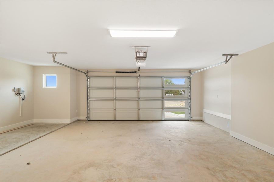 Garage with a garage door opener and baseboards Garage with a garage door opener and baseboards