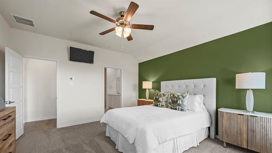 Bedroom featuring carpet floors, lofted ceiling, ceiling fan, and ensuite bathroom