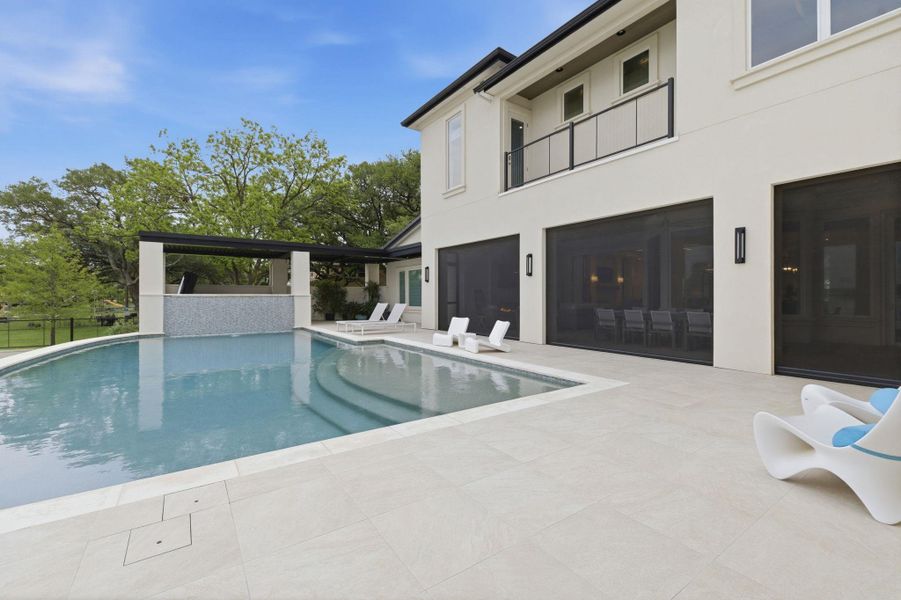 View of pool featuring patio surround and a balcony