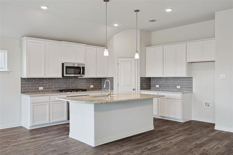 Kitchen featuring stainless steel appliances, dark hardwood / wood-style flooring, white cabinets, and backsplash