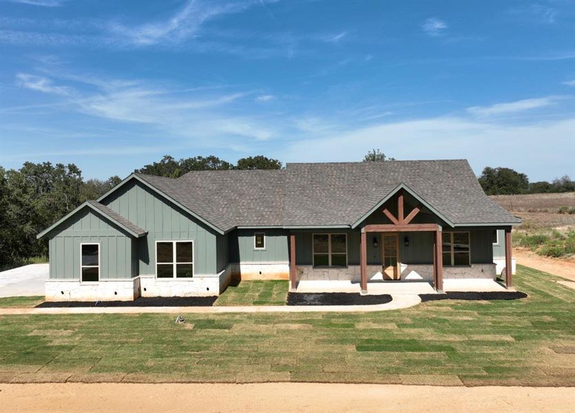 View of front facade featuring a front lawn and a porch