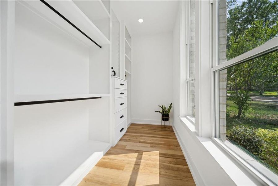 Master closet with light hardwood floors