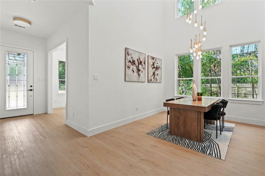 Office space featuring light wood-style floors and a towering ceiling Office space featuring light wood-style floors and a towering ceiling