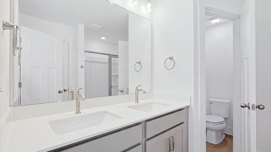 Notable primary bath featuring dual vanity, walk-in shower, and tasteful design touches throughout at El Dorado Notable primary bath featuring dual vanity, walk-in shower, and tasteful design touches throughout at El Dorado