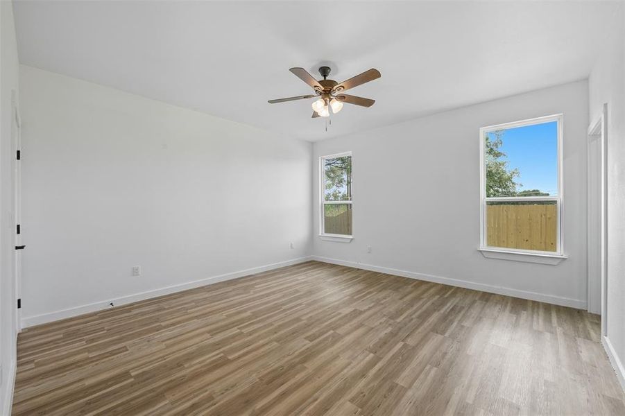 Empty room featuring light wood-type flooring and a ceiling fan Empty room featuring light wood-type flooring and a ceiling fan