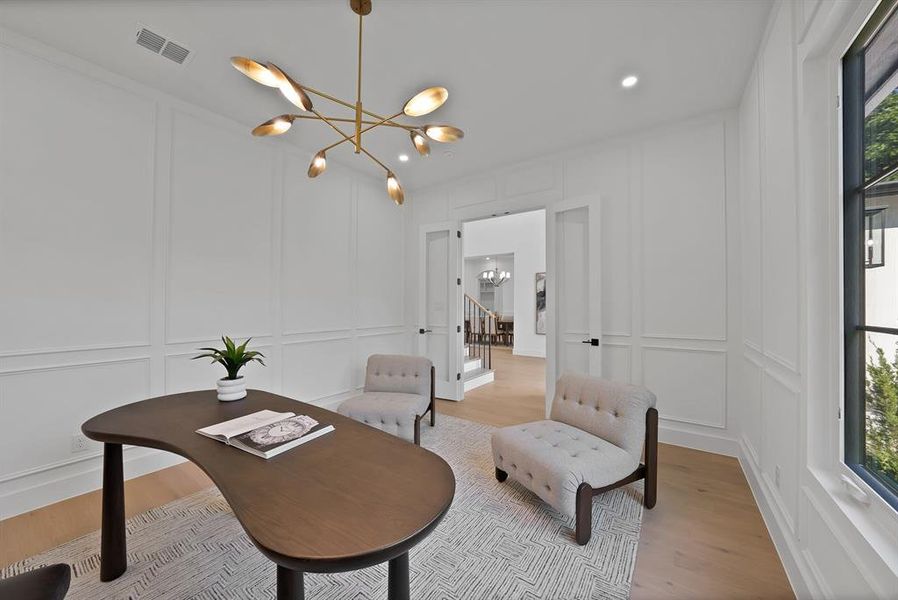 Office space featuring wainscoting, a modern chandelier, light wood-finish flooring, and French doors