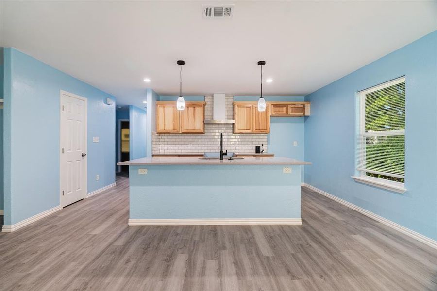 Kitchen featuring light brown cabinetry, light wood finished floors, decorative backsplash, a center island with sink, and recessed lighting Kitchen featuring light brown cabinetry, light wood finished floors, decorative backsplash, a center island with sink, and recessed lighting