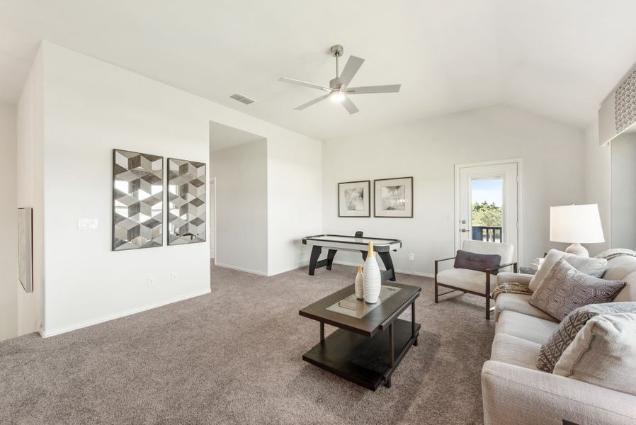 Carpeted game room with air hockey table, seating area, and ceiling fan on vaulted ceiling