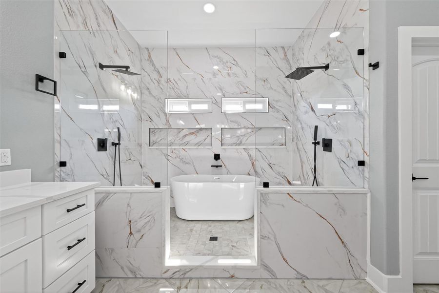 Luxurious primary bath with dual vanities, soaking tub, and spacious shower. Luxurious primary bath with dual vanities, soaking tub, and spacious shower.