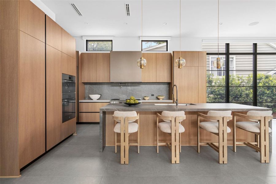 [Gathering Kitchen]The great room gives way to a kitchen of genuine grandeur, anchored by a waterfall island, Poliform cabinetry, and a suite of Miele appliances with a fully appointed chef's prep kitchen concealed behind it, so the main space remains flawless no matter the occasion.