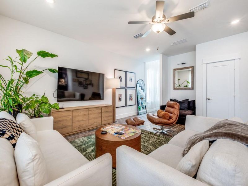 Living room with a ceiling fan and recessed lighting