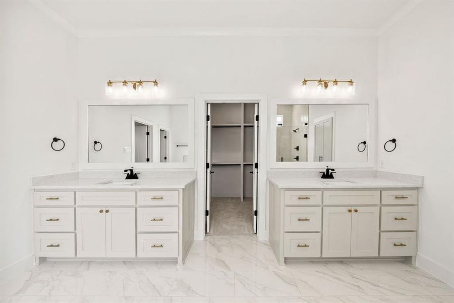 Full bath featuring two vanities, a walk in closet, light marble finish floors, a stall shower, and ornamental molding Full bath featuring two vanities, a walk in closet, light marble finish floors, a stall shower, and ornamental molding