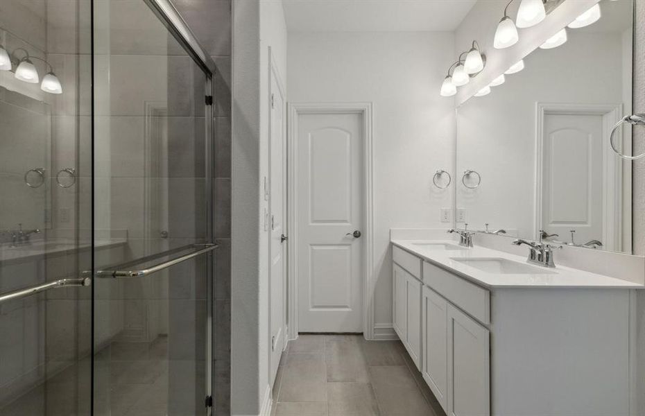 Elegant owner's bathroom with dual vanity and oversized shower*real home pictured