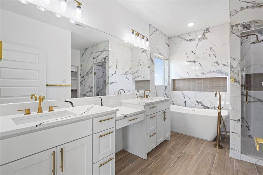 Full bathroom featuring a marble finish shower, a soaking tub, two vanities, double vanity, and tile walls Full bathroom featuring a marble finish shower, a soaking tub, two vanities, double vanity, and tile walls
