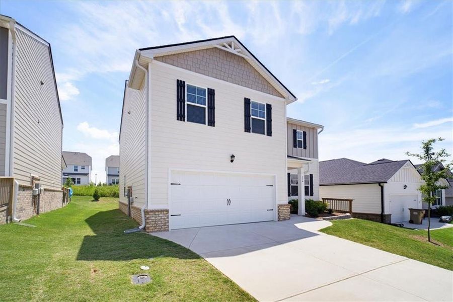 Front exterior of a new home in Twin Lakes, Hoschton, GA, highlighting curb appeal (Image 28). Front exterior of a new home in Twin Lakes, Hoschton, GA, highlighting curb appeal (Image 28).