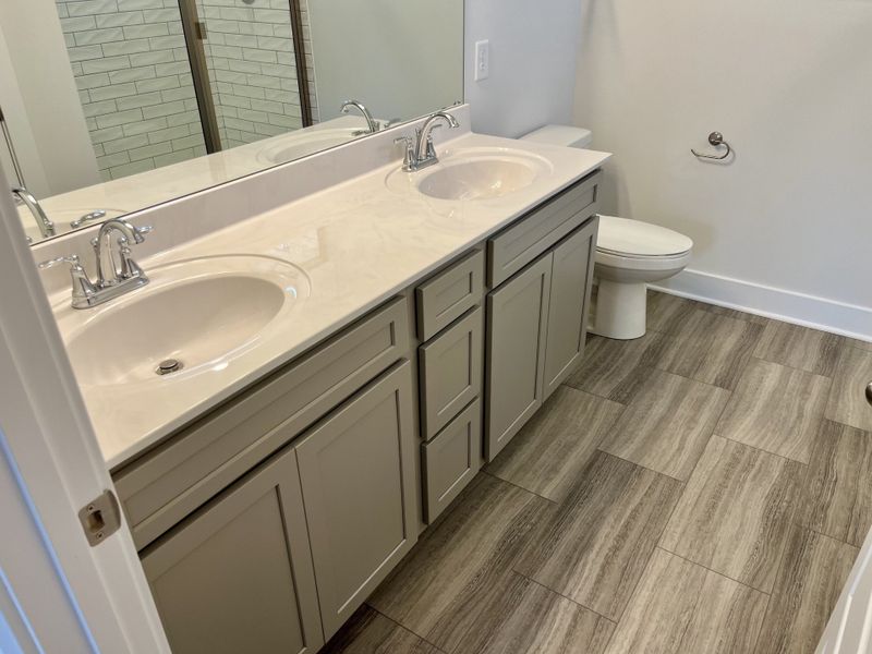Stock showing Double raised vanity, comfort height toilet, LVT and 5 ft tile shower