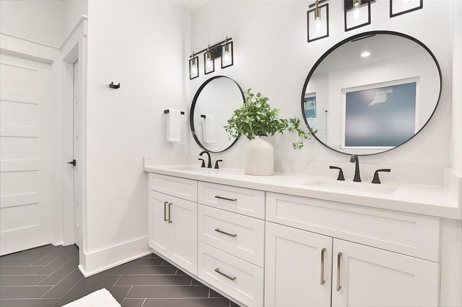 Experience the elegance of a primary bath featuring chic herringbone floor tiles and sleek 24x12 European porcelain tiles in the shower.