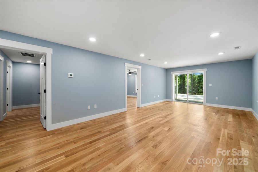 Lower level living area with bedroom door to left of sliding door and zero entry access from second driveway