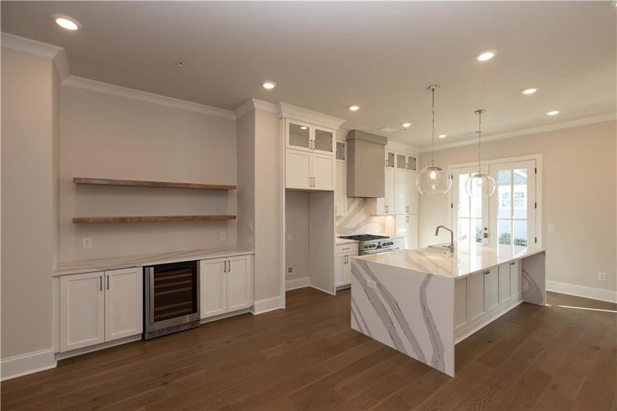 Kitchen layout flows into open concept - featuring crown molding, bar area, recessed lighting and hard surface flooring.  Image is of previously built Chamberlain plan.