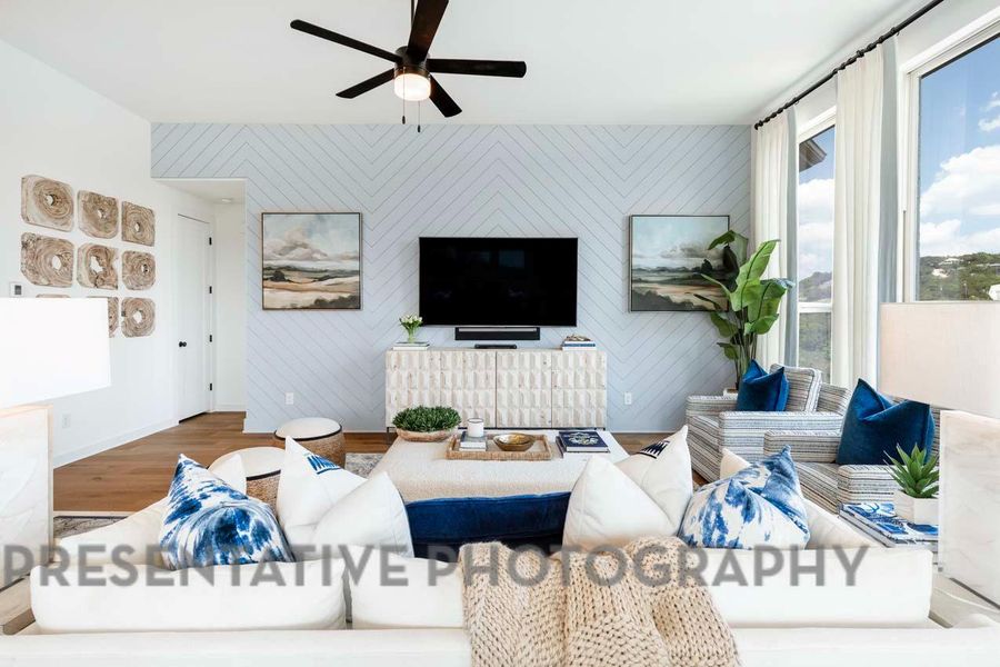 Living area featuring ceiling fan, baseboards, and wood finished floors